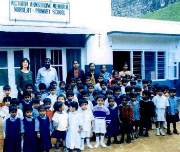 Children at NAWA with school building behind